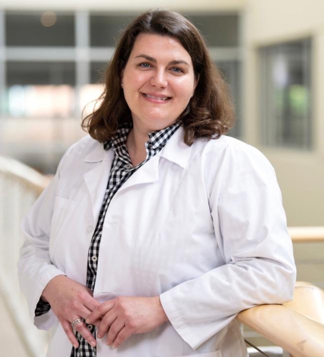 A nursing student looking at the camera for a photo in a hallway.